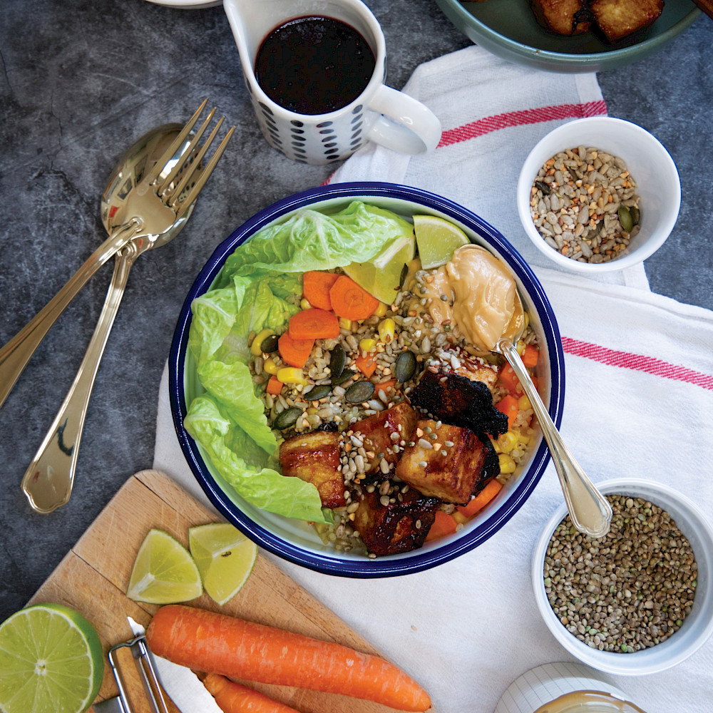 Eine bunte Bowl auf Quinoa Basis mit Tofu und Gemüse.