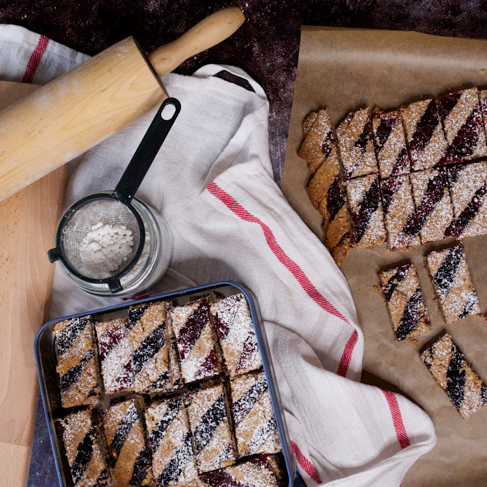 Linzer-Weihnachtskekse: Ein zarter Mürbeteig mit Mandeln, bestrichen mit fruchtiger Marmelade und verziert mit einem Teiggitter – goldbraun gebacken und himmlisch lecker!